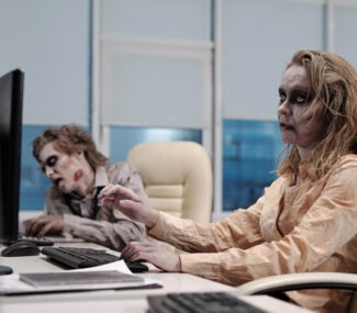 ugly,zombie,female,sitting,in,armchair,in,front,of,computer